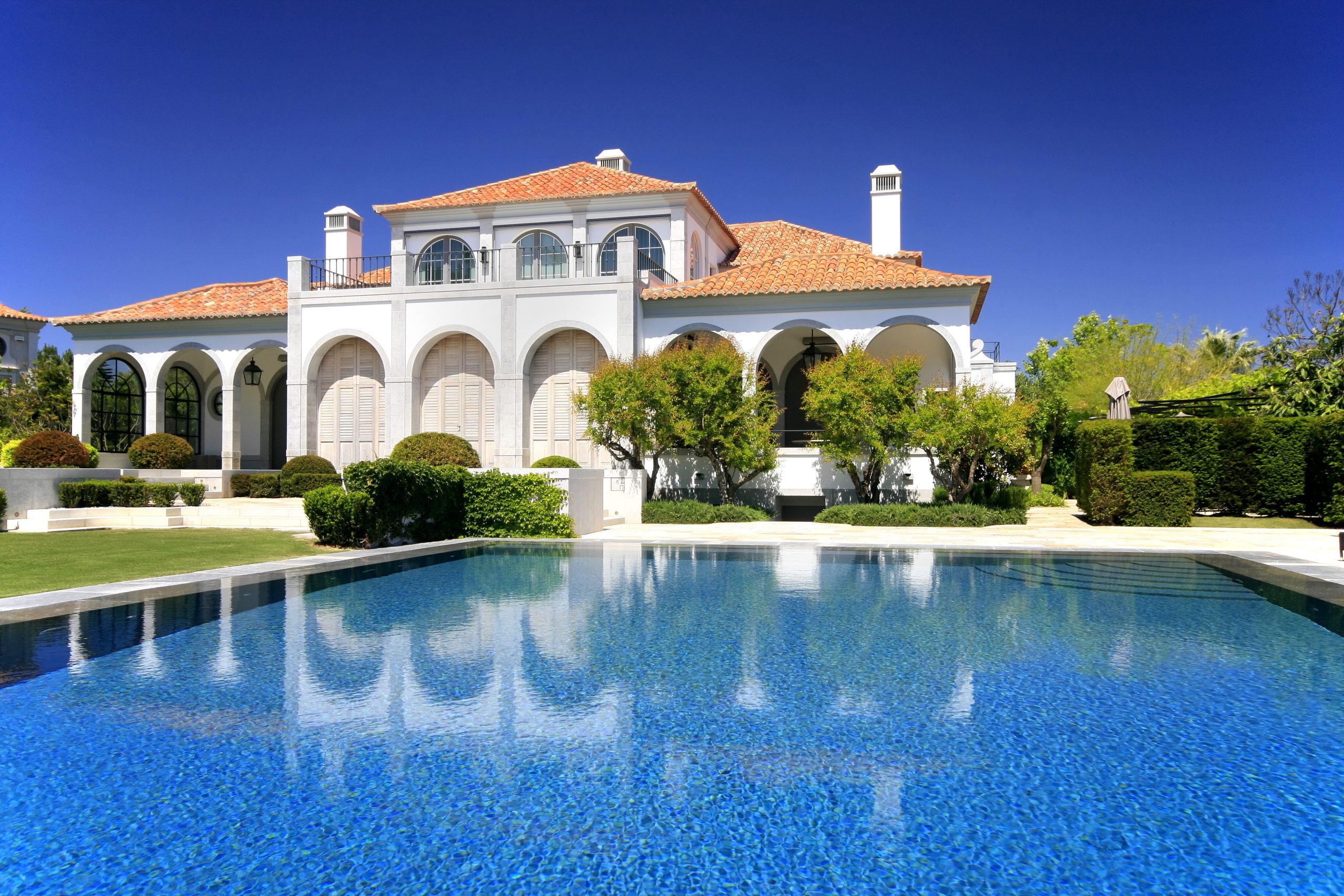 Modern luxurious home with a big pool in the foreground