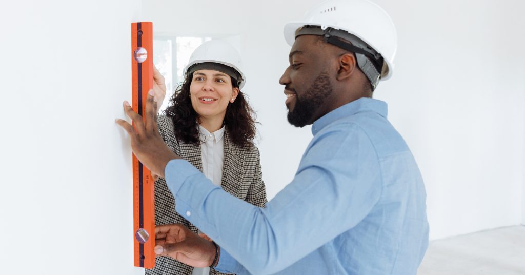 Couple measuring a wall inside their home