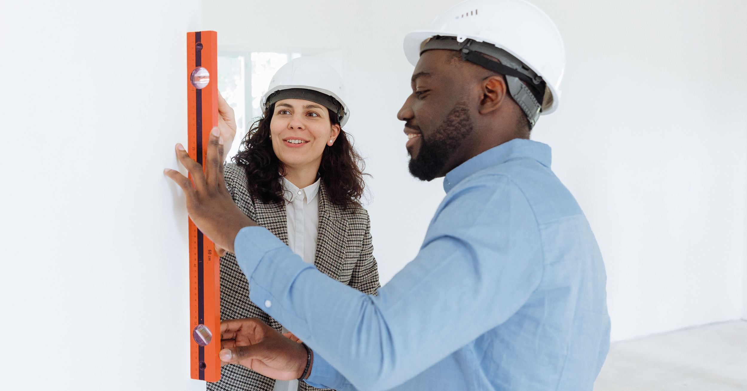 Couple measuring a wall inside their home